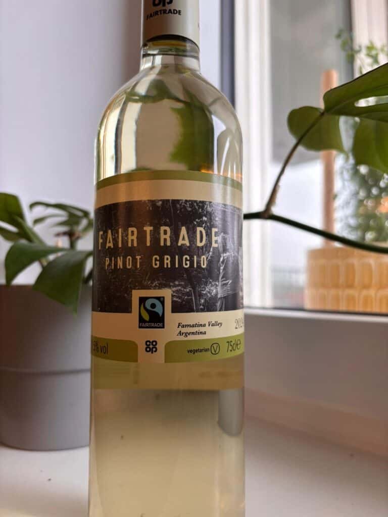 botthel of white wine in a backdrop with a plant and a yellow planter