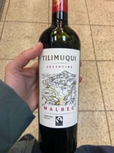 hand holding a bollte of read wine