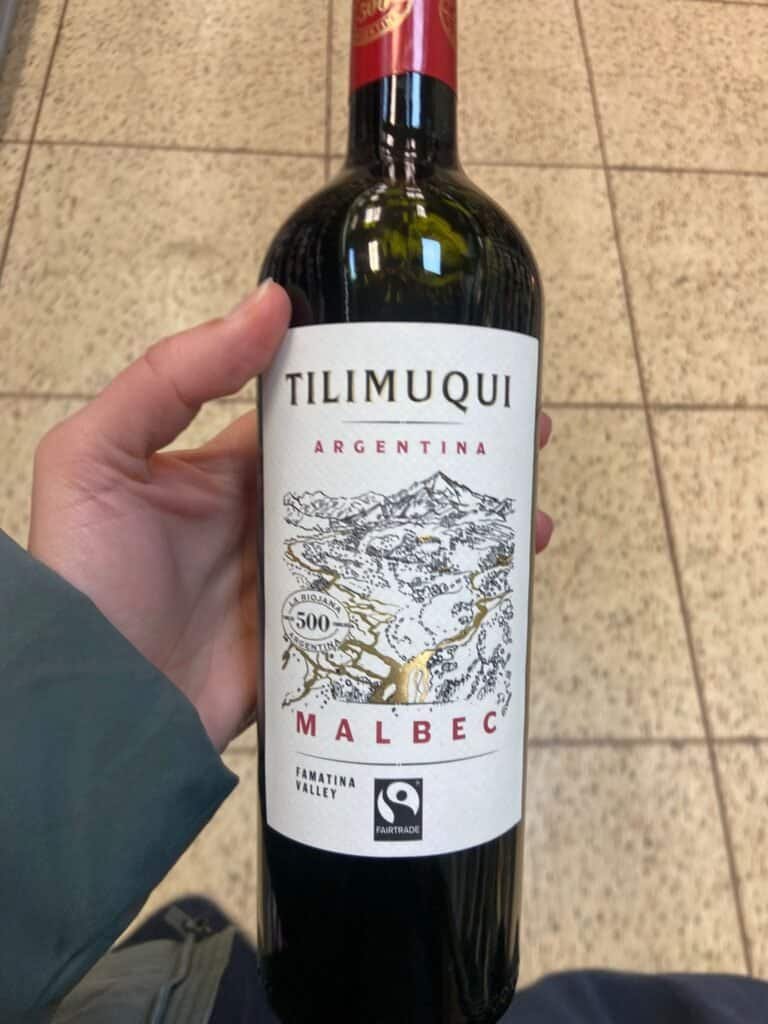 hand holding a bollte of read wine