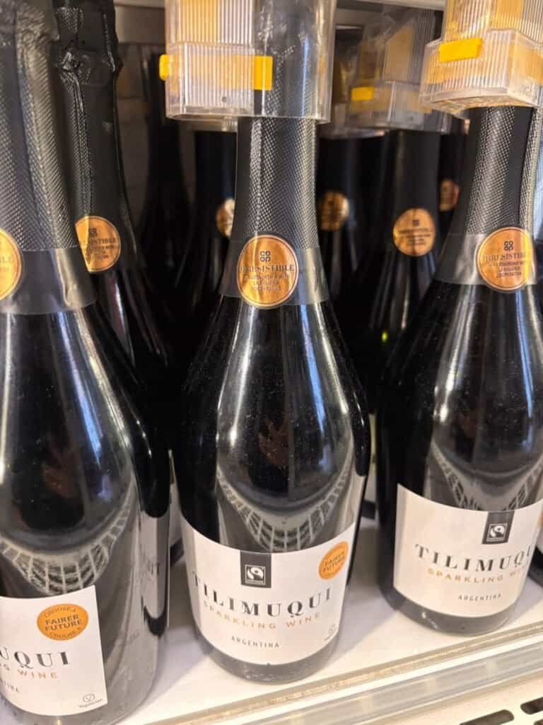 bottles of wine line on a supermarket shelf